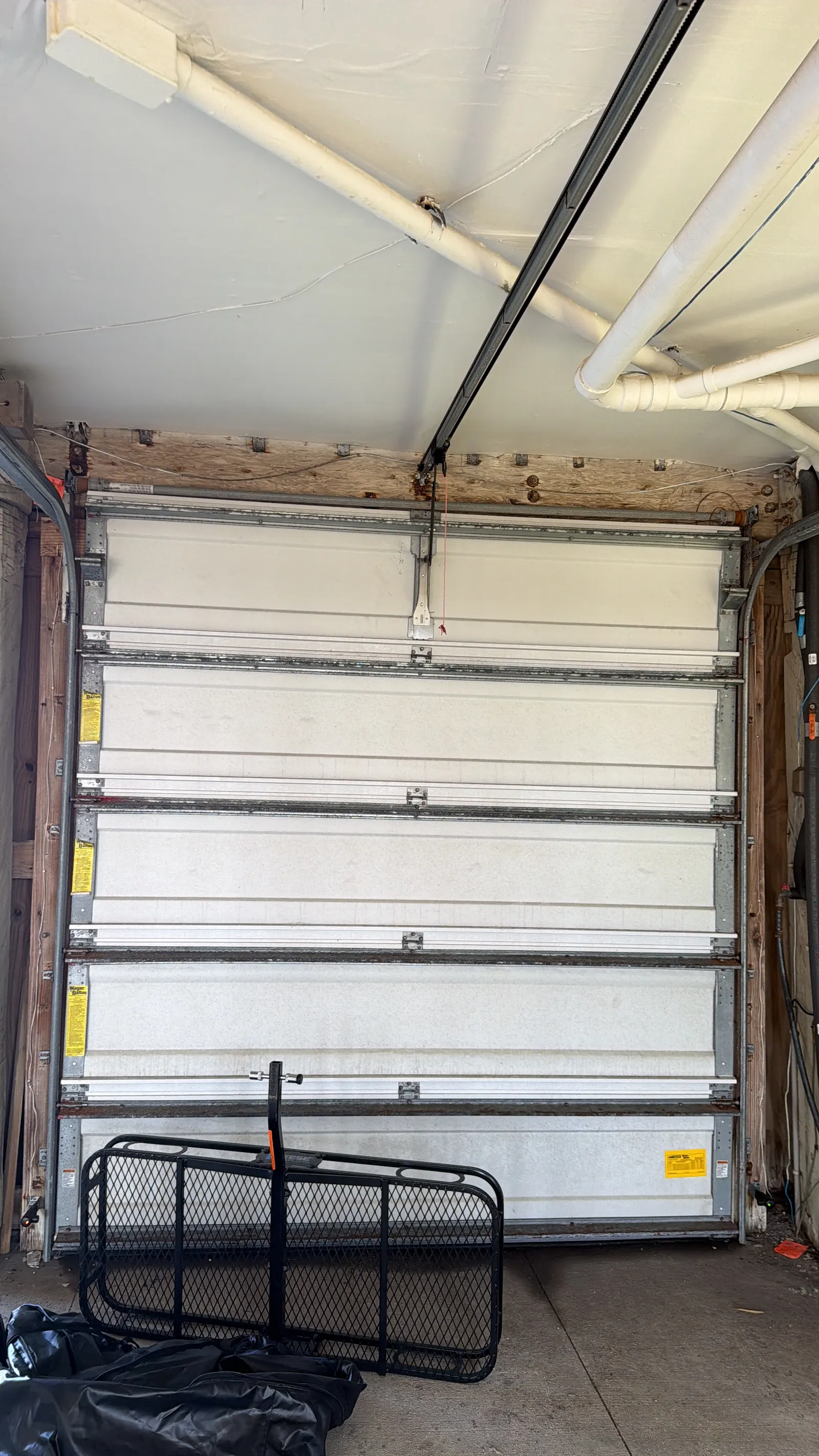 Inside view of a sectional garage door in a wood-framed garage