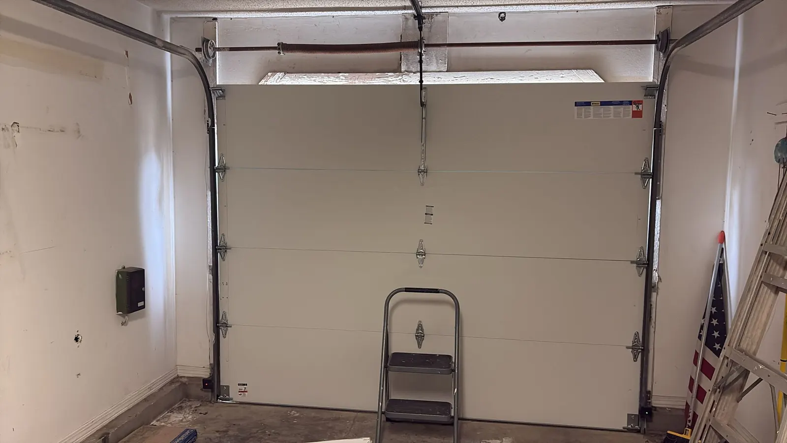 Inside view of a closed insulated garage door with the opener arm attached