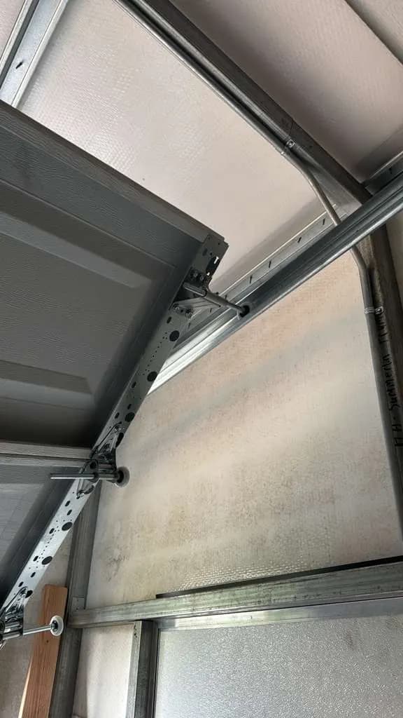 Bent garage door panel and twisted track after an impact