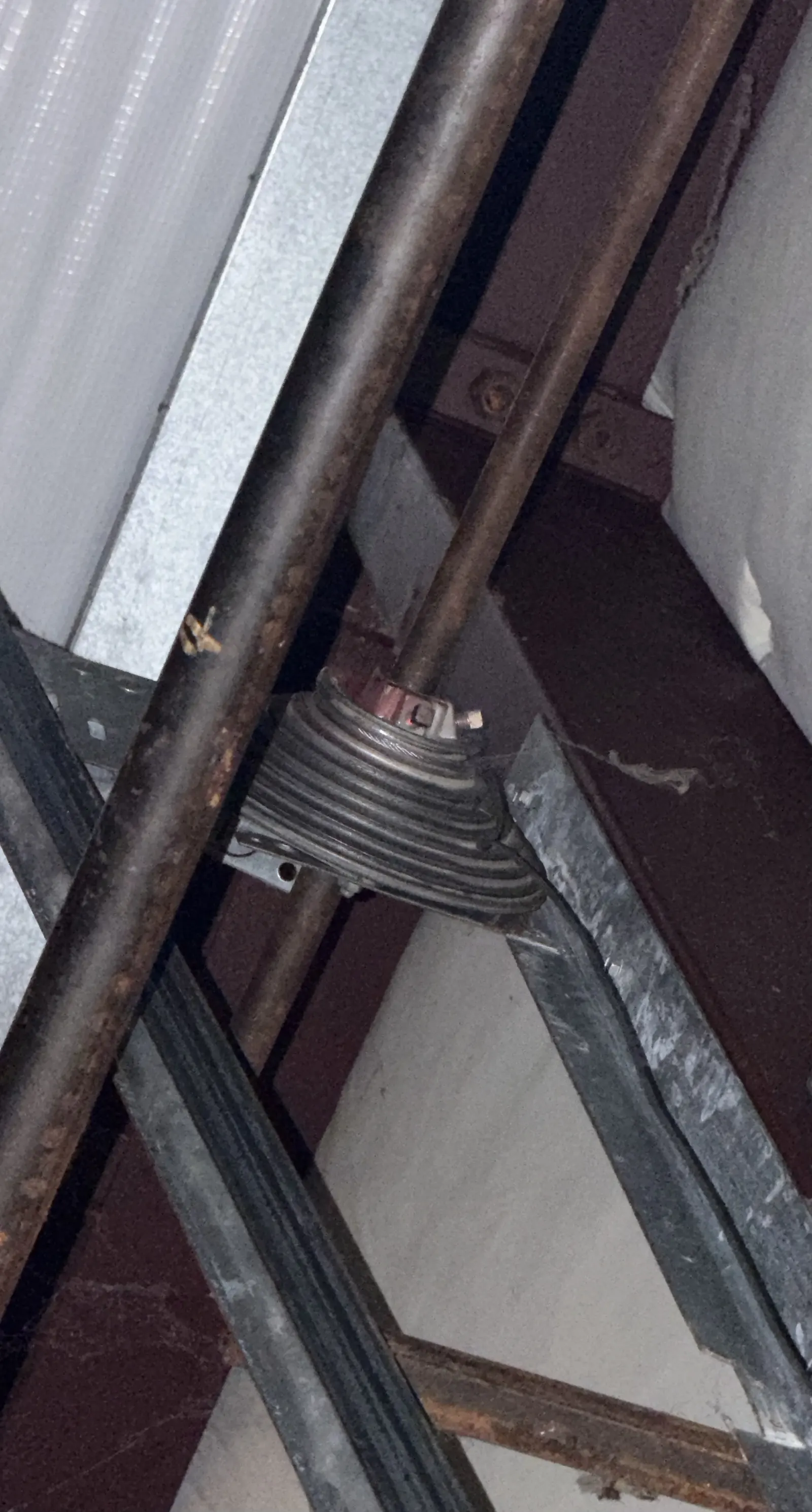 Torsion spring and cable drum mounted above a garage door