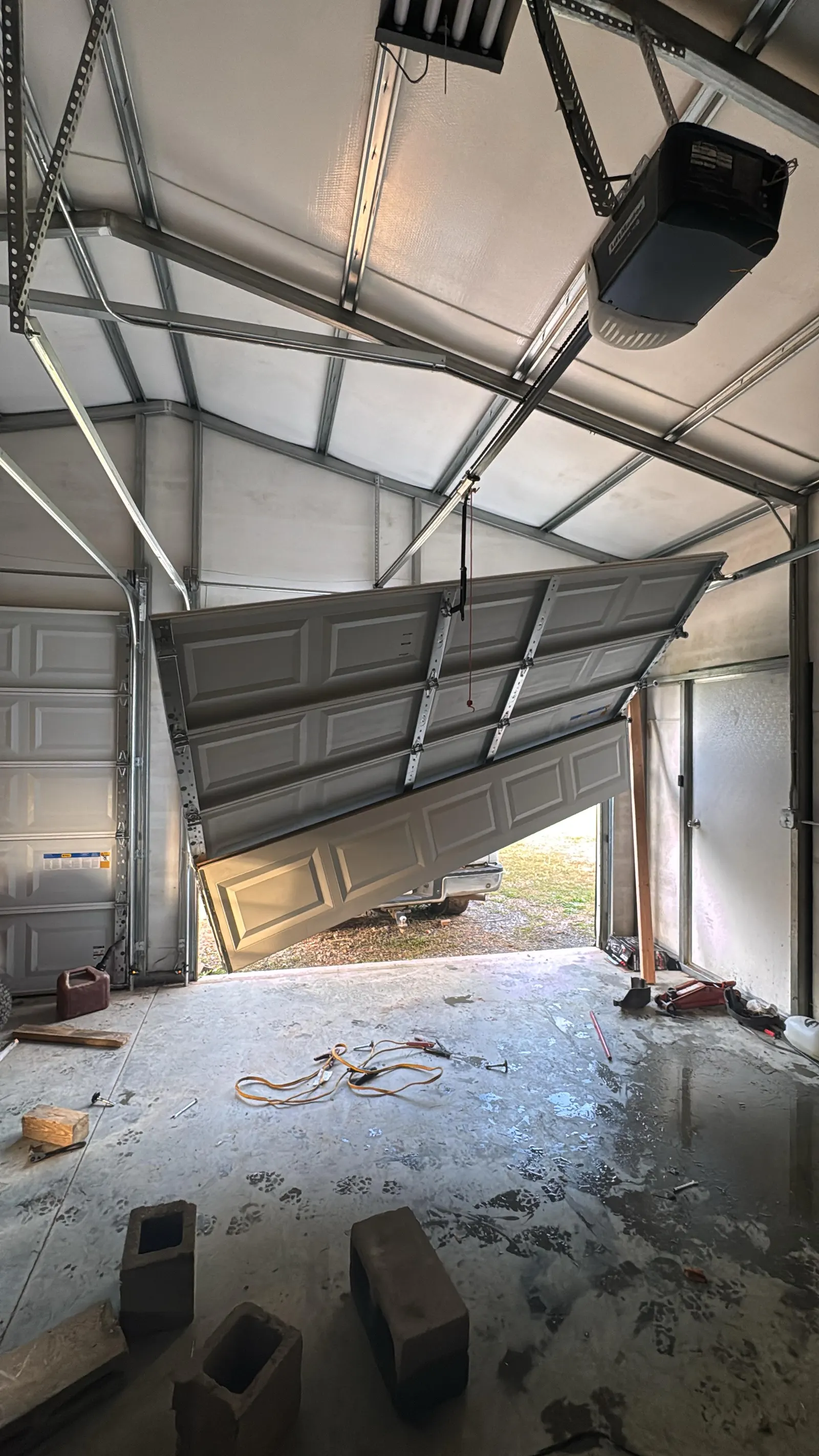 Two-car garage door twisted off track inside the garage