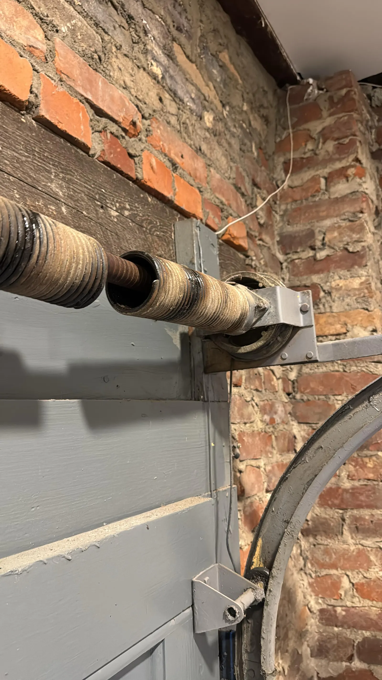 Torsion spring on the header of a brick garage