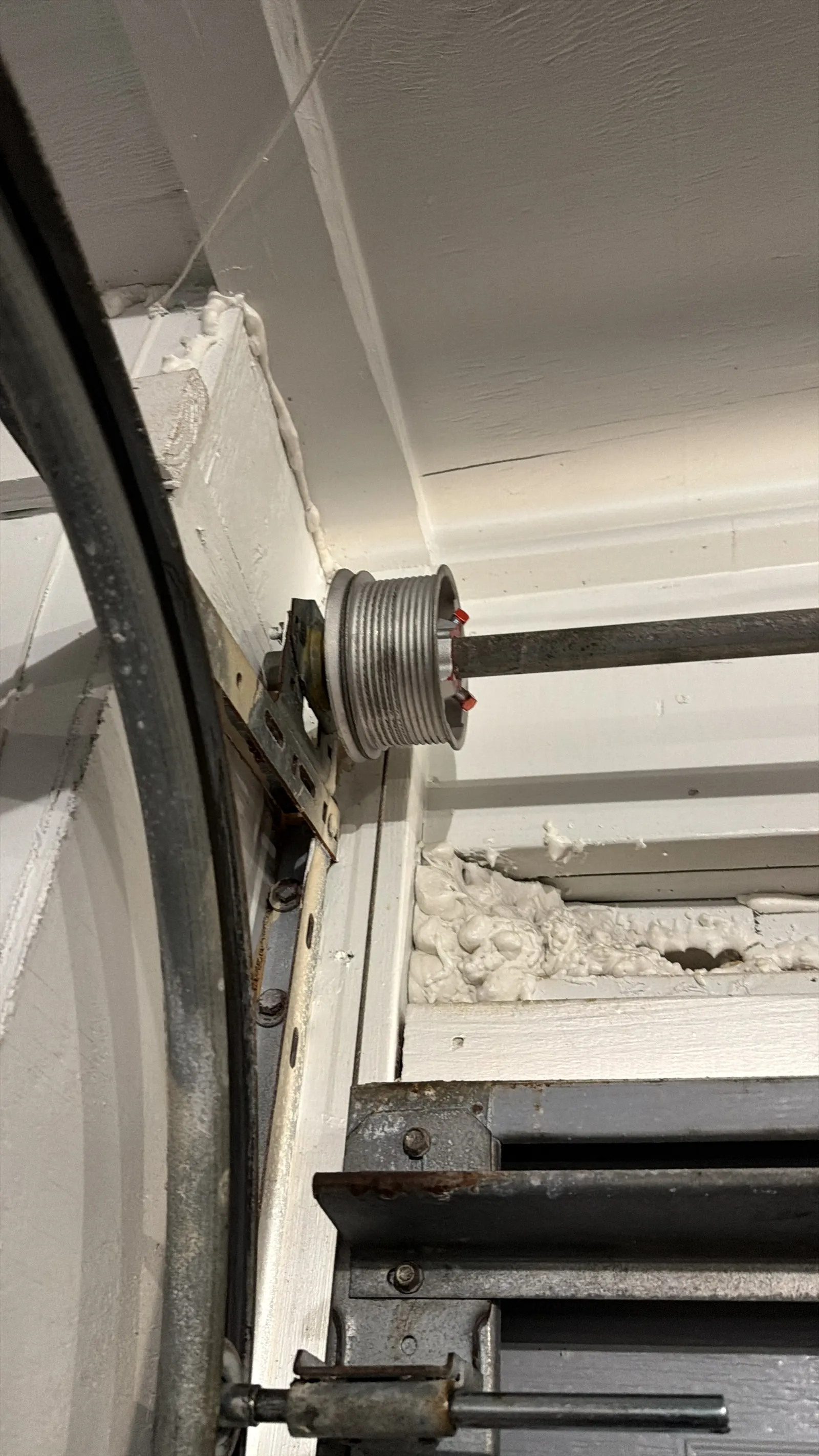 Cable drum and lift cable at the top corner of a garage door