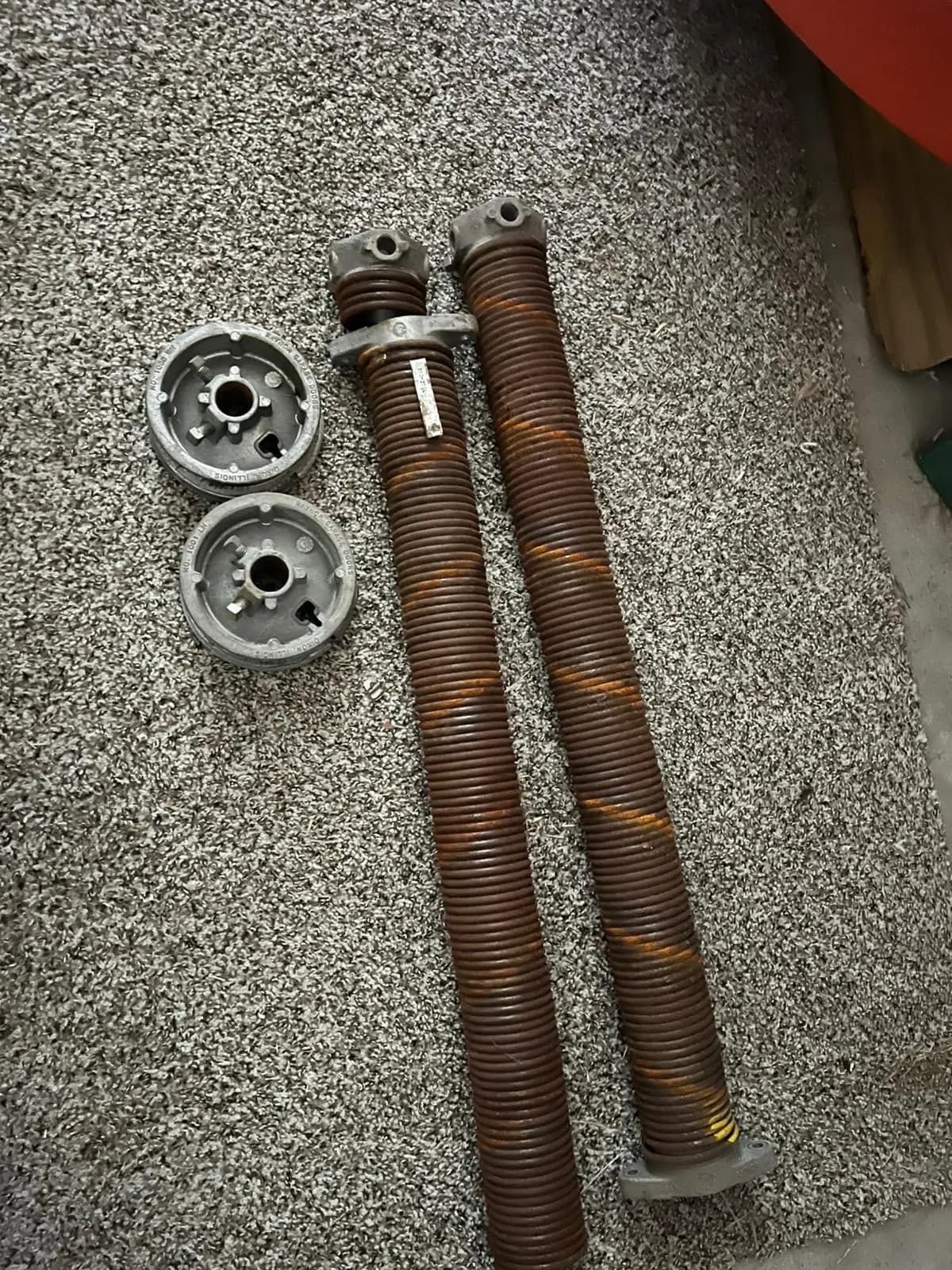 Pair of worn torsion springs and cones removed from a door