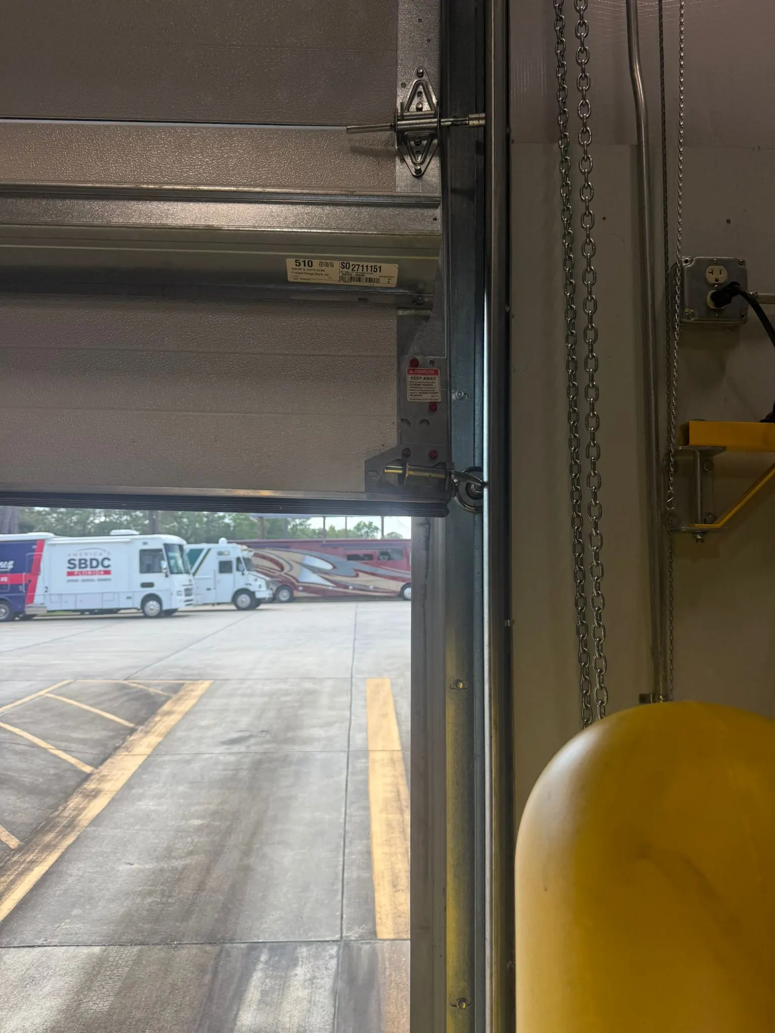 Open commercial door looking out to a parking lot