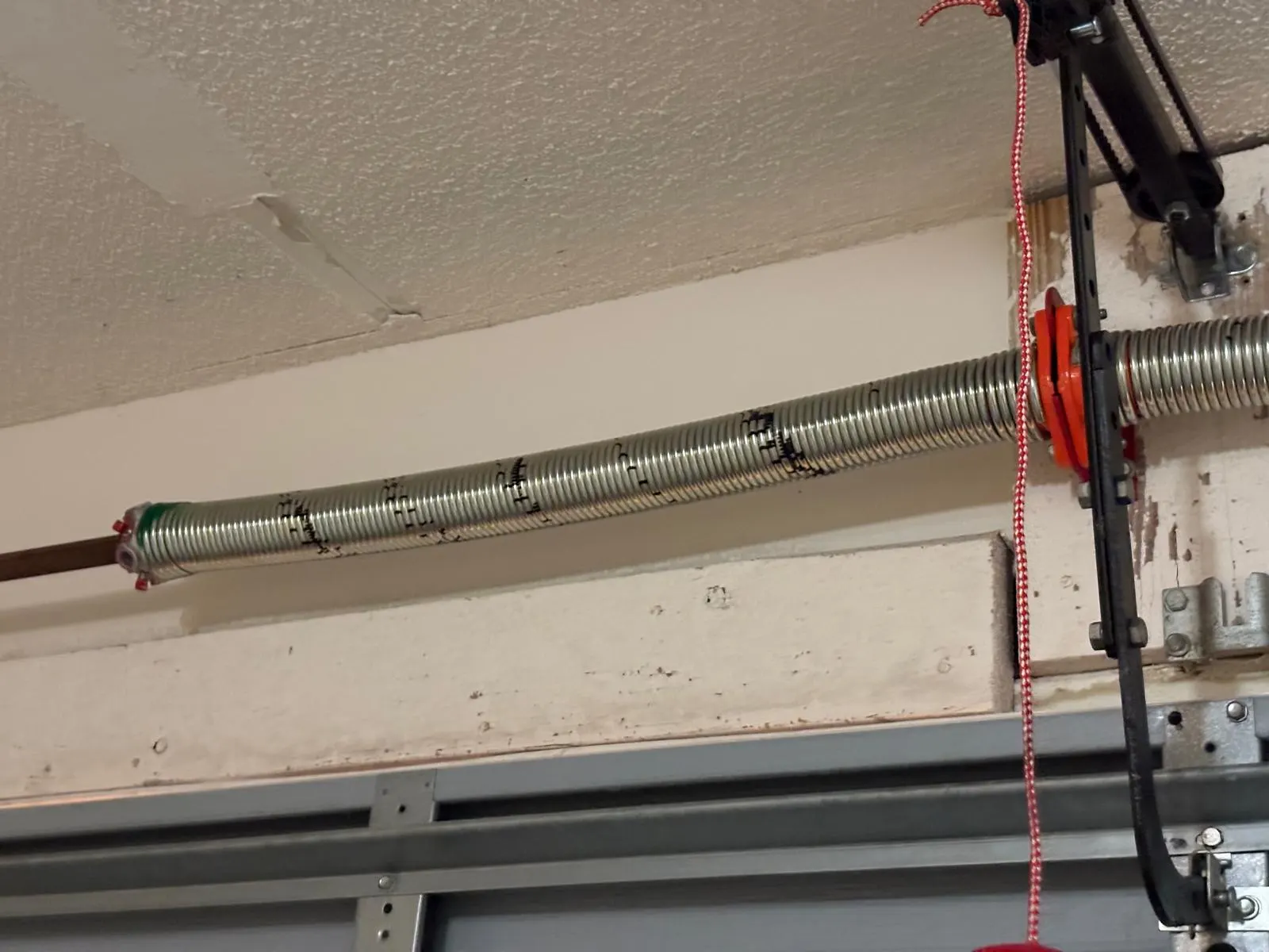 Torsion spring and opener above a residential garage door